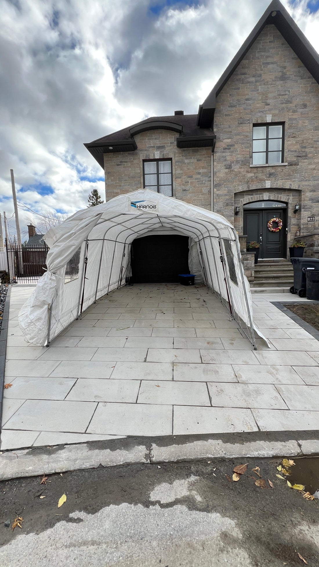 Abri d’auto monté dans une entrée pavée devant une maison