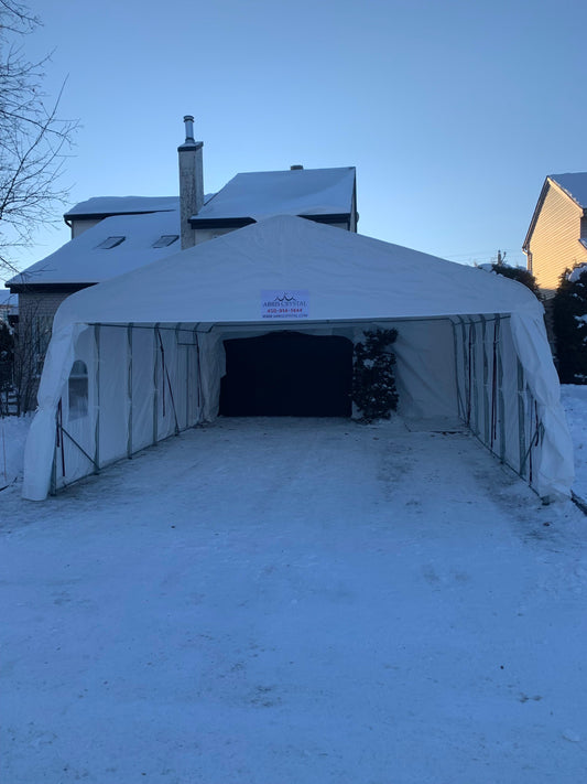 Abri d’auto double monté devant une maison dans une entrée enneigée