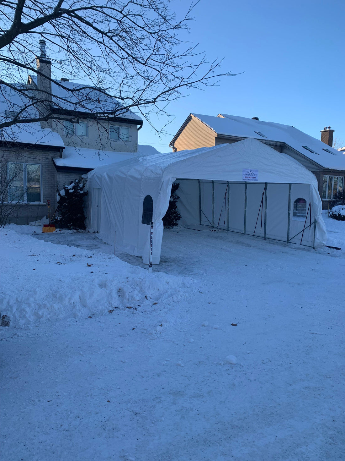 Abri d’auto installé devant une résidence en hiver