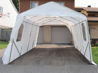 Abri d’auto simple blanc vu de face, ouvert et sans véhicule, devant un garage.