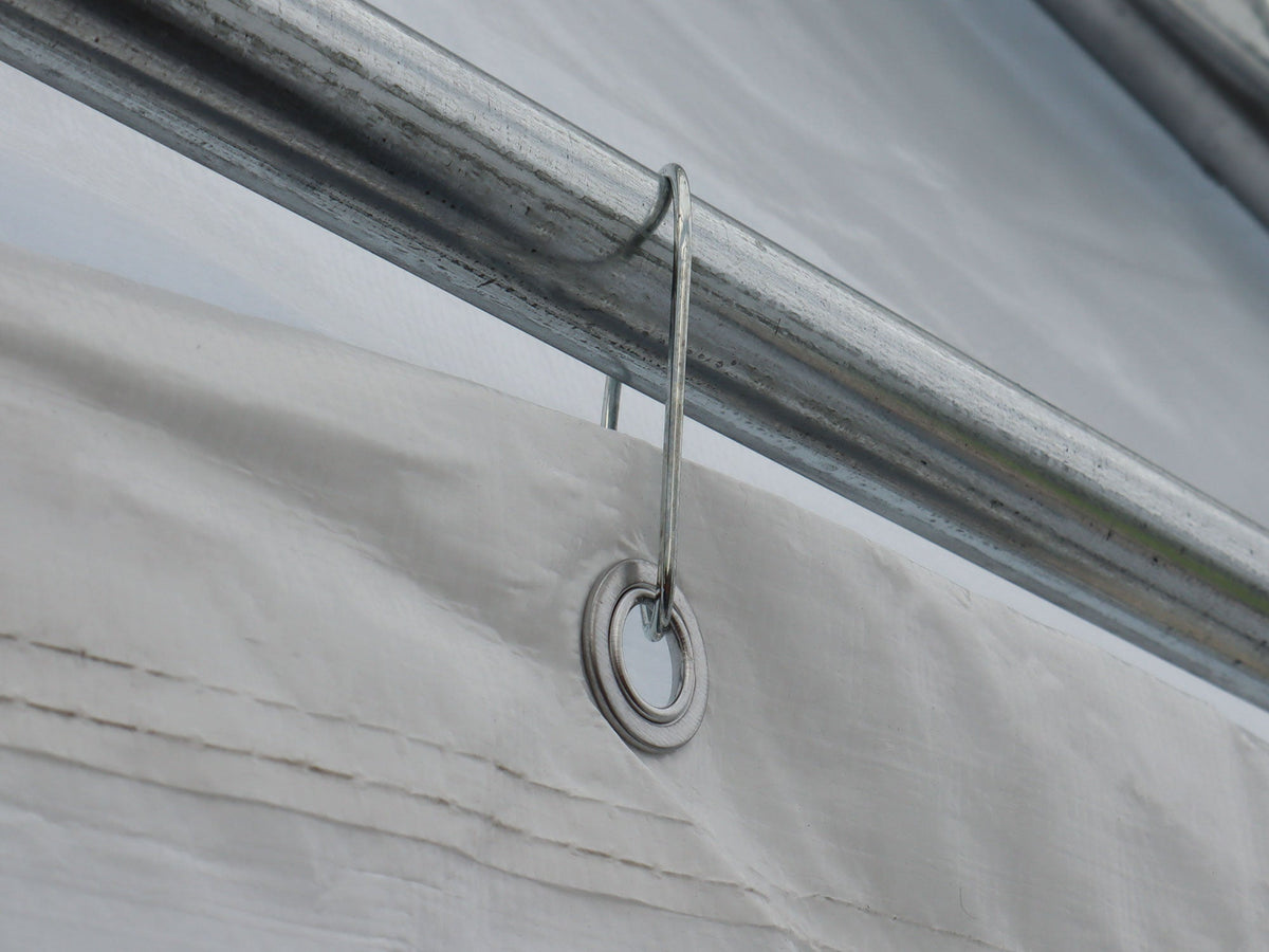 Crochet maintenant un œillet de toile sur un tube de la structure d’un abri.