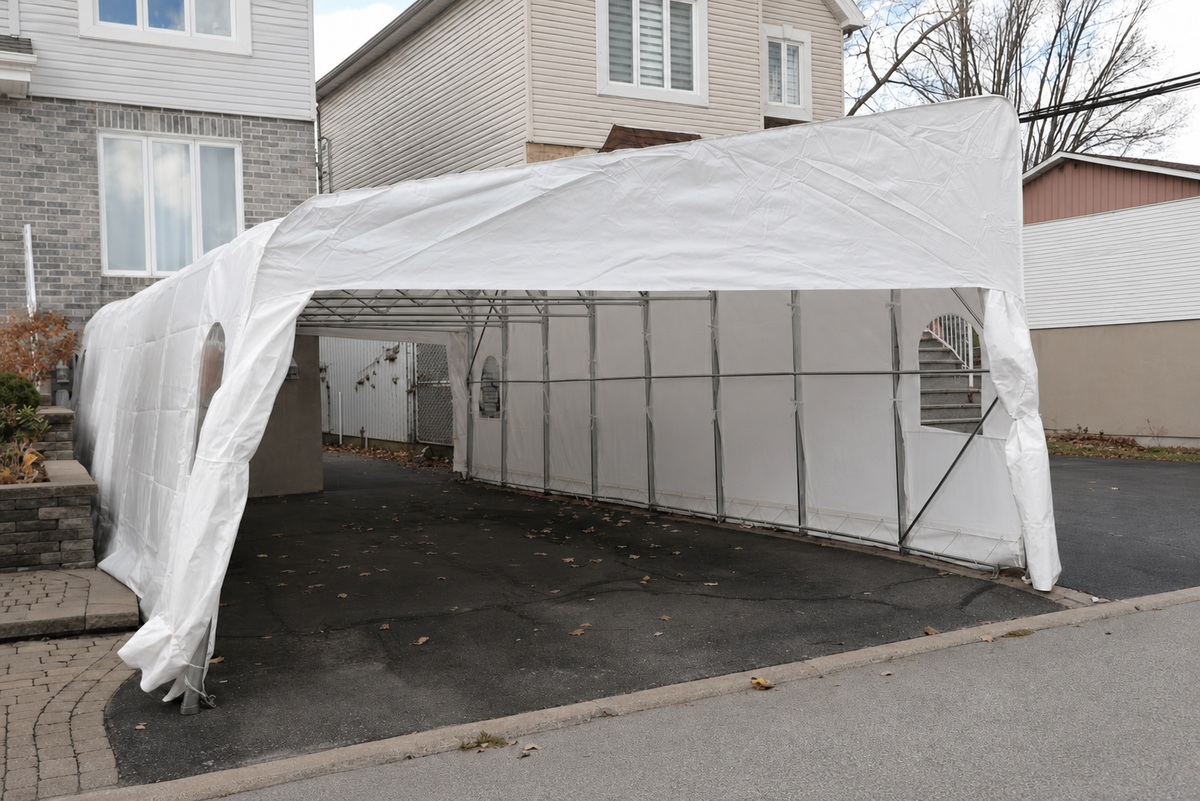 Abri double monopente blanc vu de côté, avec sa toiture inclinée et son intérieur visible.